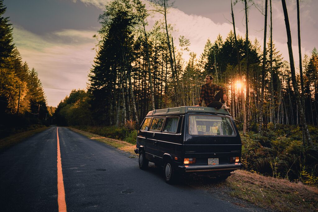 Camper van on a forest road at sunrise, Canada